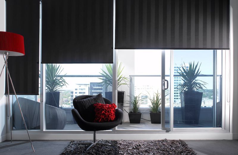 A Living Room With A Black Chair And A Sliding Glass Door — Mid Coast Flooring & Blinds In Wingham, NSW