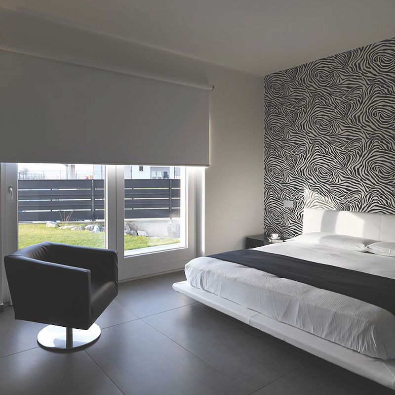 A Bedroom With A Large Bed And A Chair — Mid Coast Flooring & Blinds In Taree, NSW