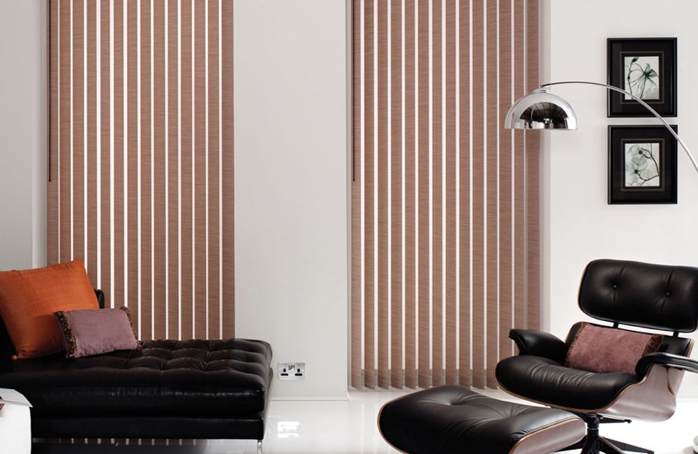 A Living Room With Vertical Blinds And A Black Chair — Mid Coast Flooring & Blinds In Taree, NSW