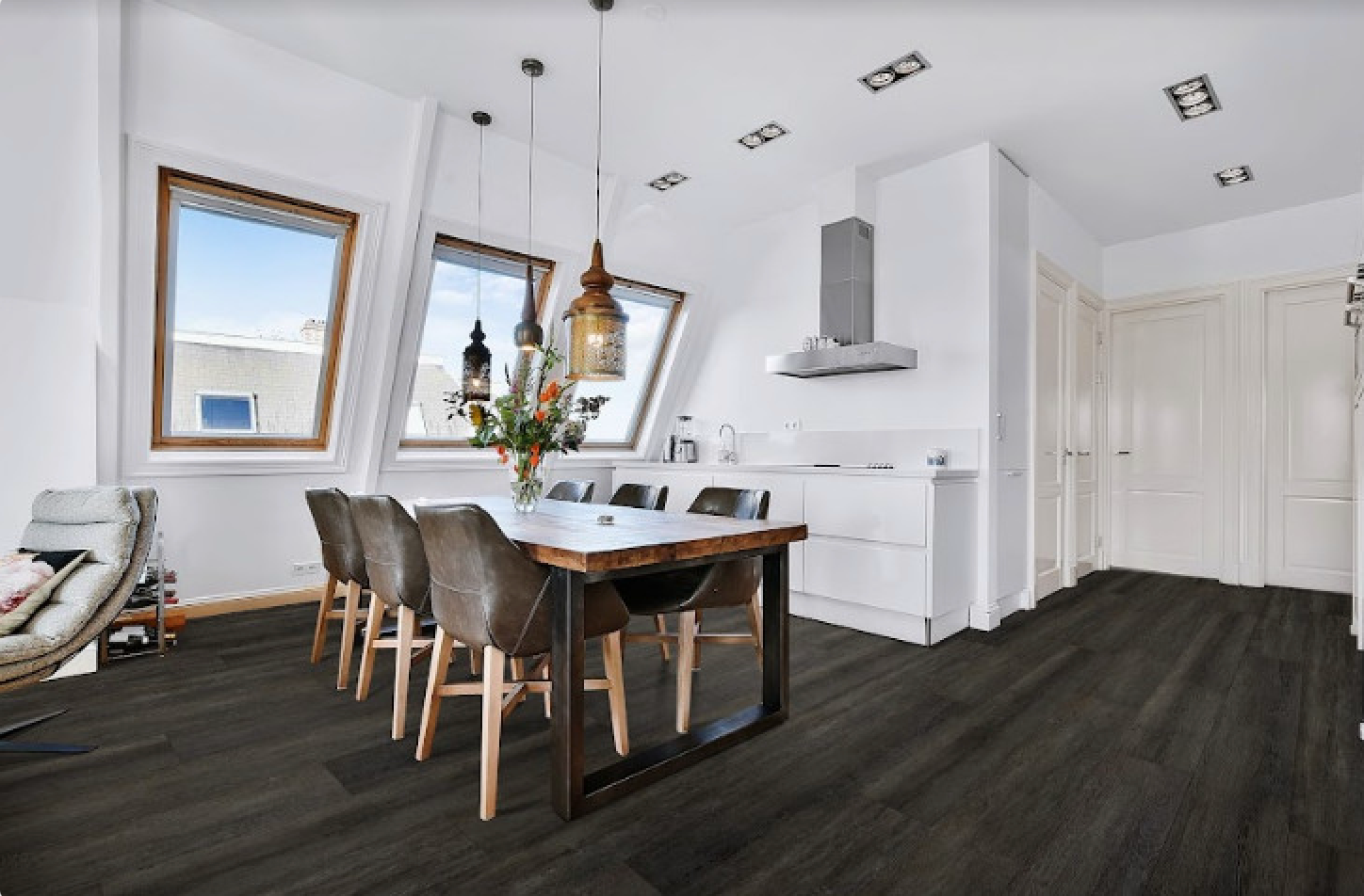 A Person Is Laying A Piece Of Vinyl Flooring On A Wooden Floor — Mid Coast Flooring & Blinds In Laurieton, NSW