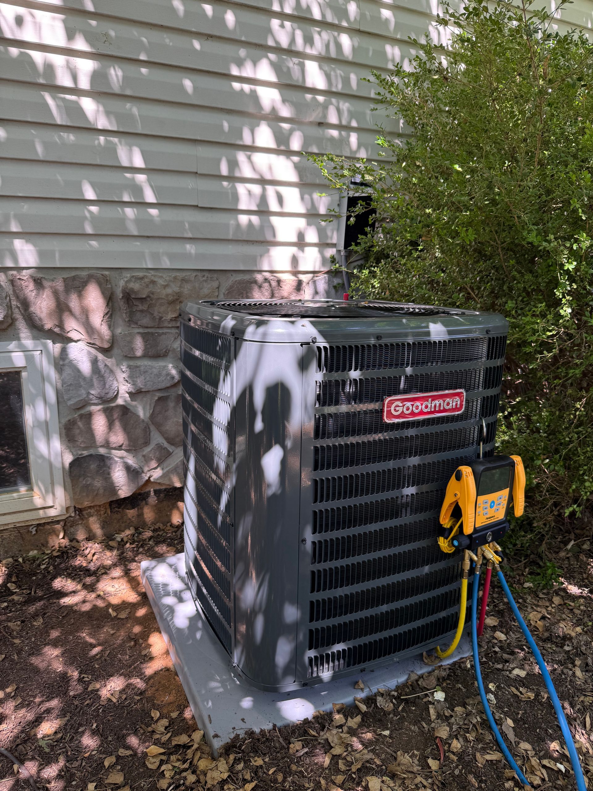 An air conditioner is sitting outside of a house covered in foam.