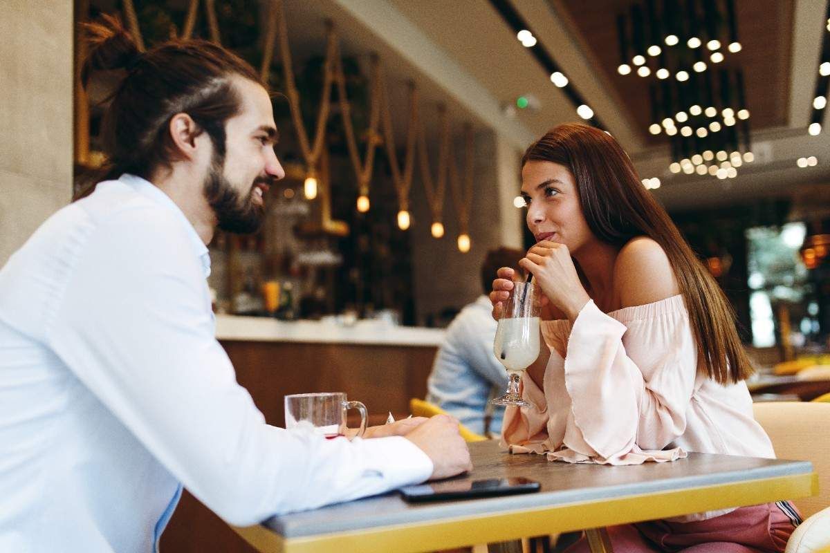 couple sitting in cafe and looking at each other