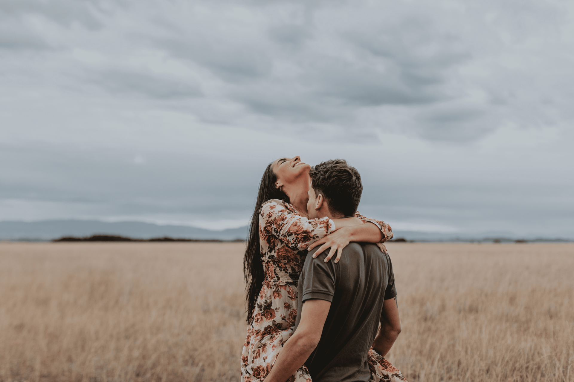 boy holding a girl in his hand kissing 