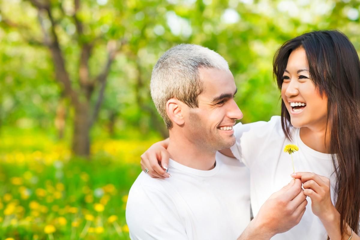 couple laughing holding a flower