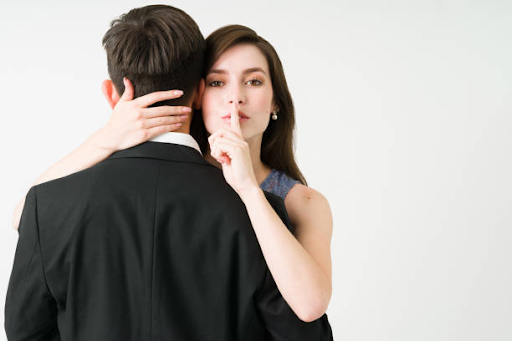 girl hugging a man putting her finger on the lips