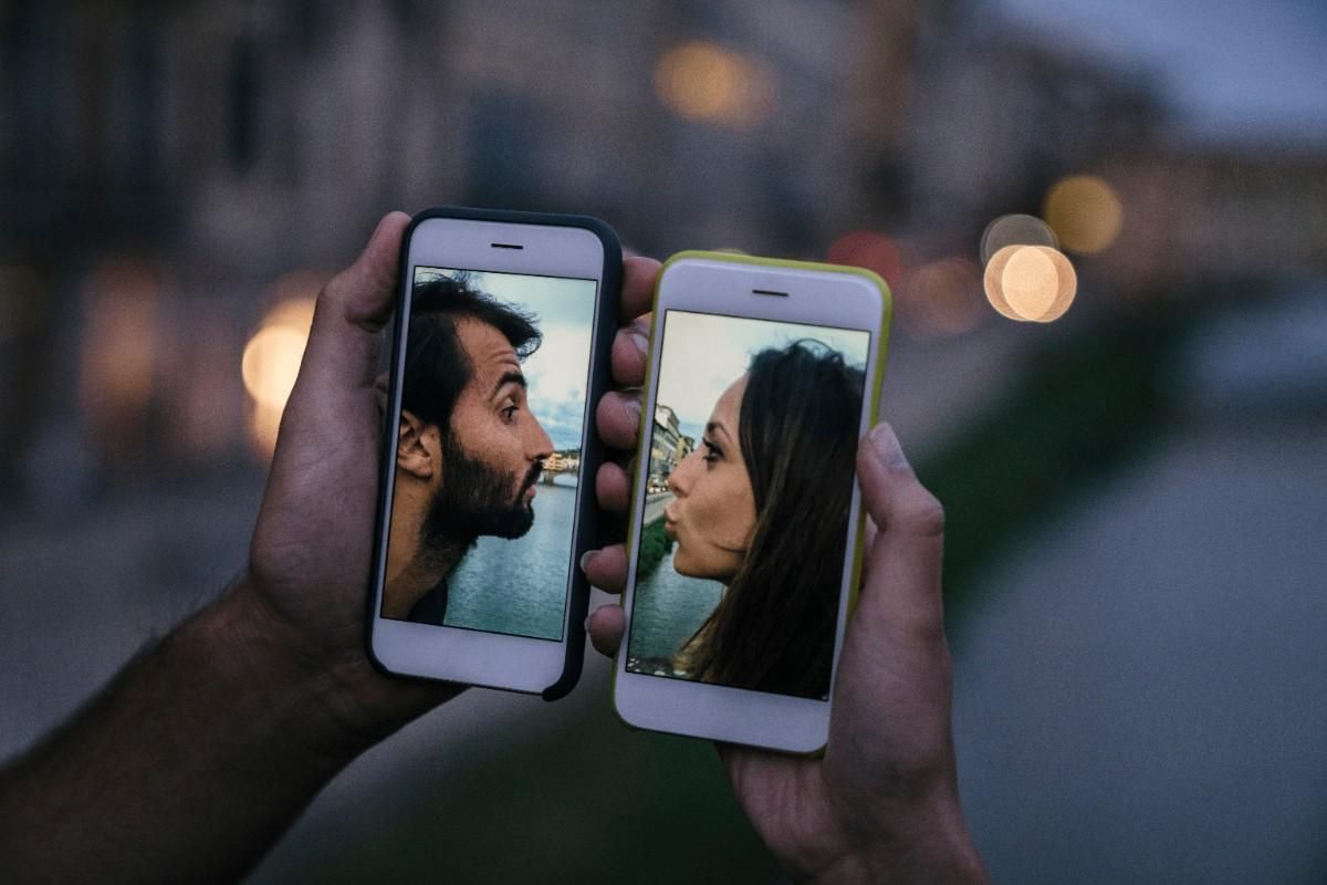 two mobile screens displaying couples kissing