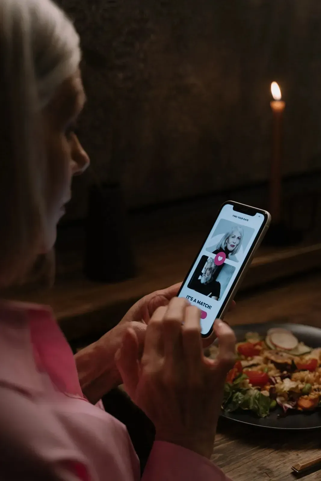 Woman browsing a dating app, weighing the difference between online dating and hiring a matchmaker.