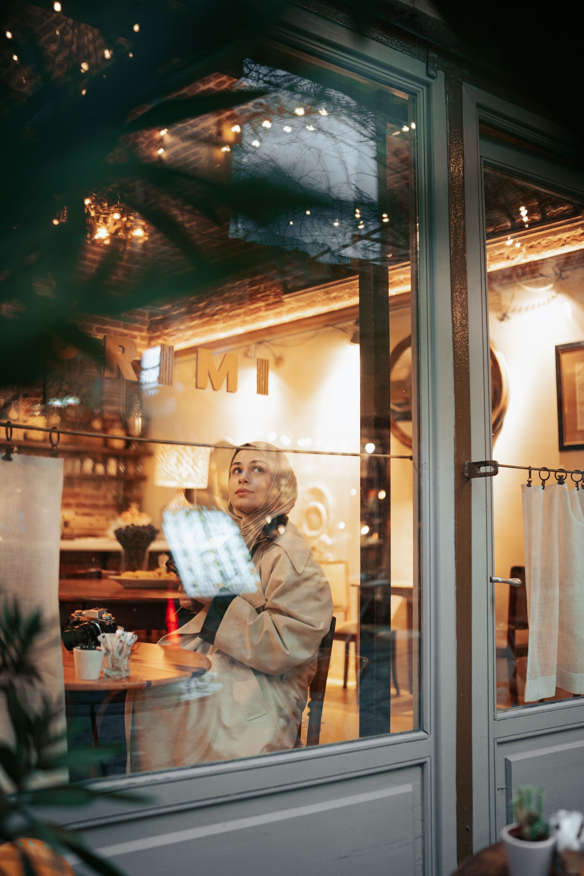 A composed professional woman sitting alone at a cafe window, reflecting on her next chapter