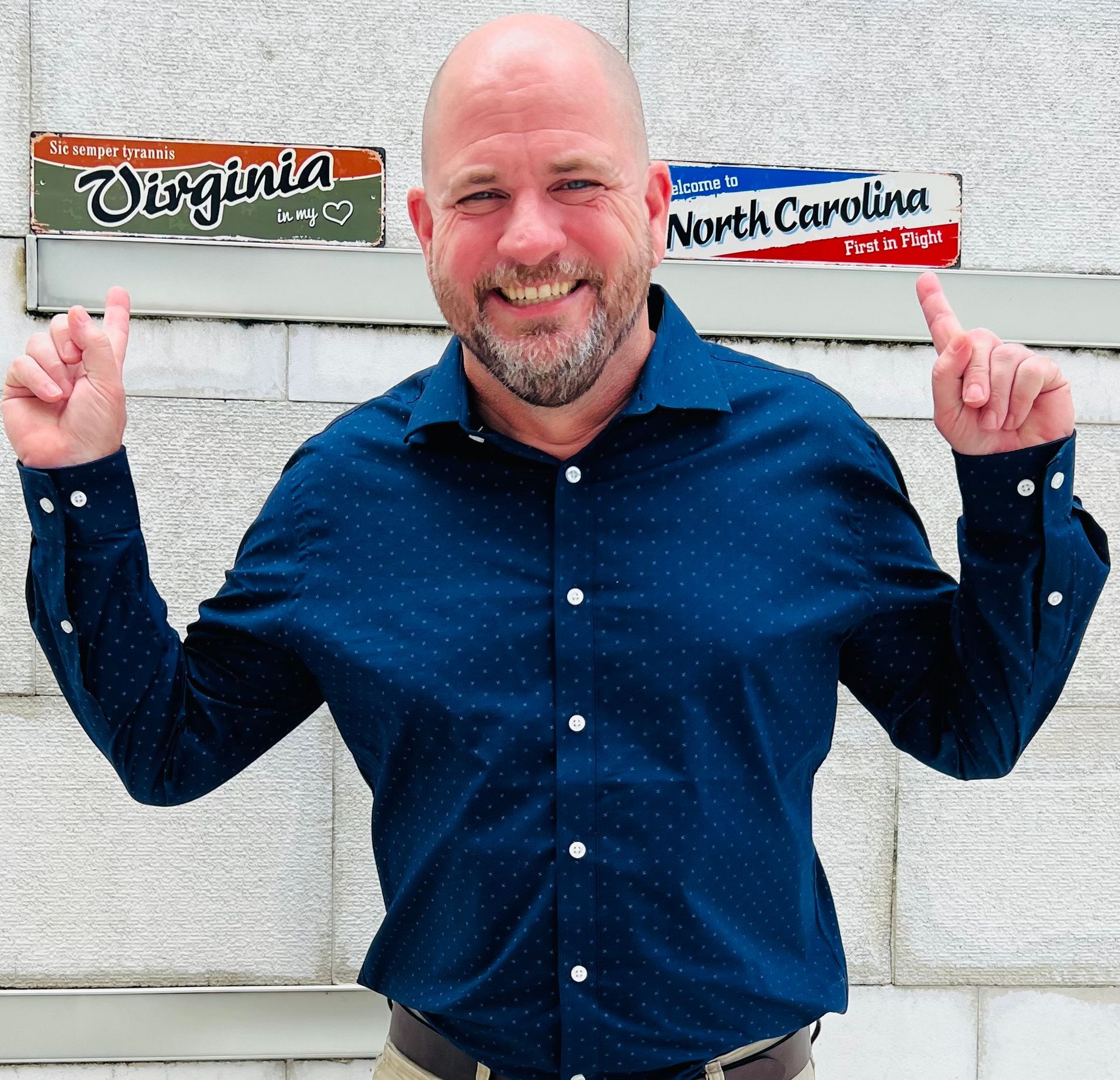 A woman is sitting at a desk with a laptop and a vase of flowers.
