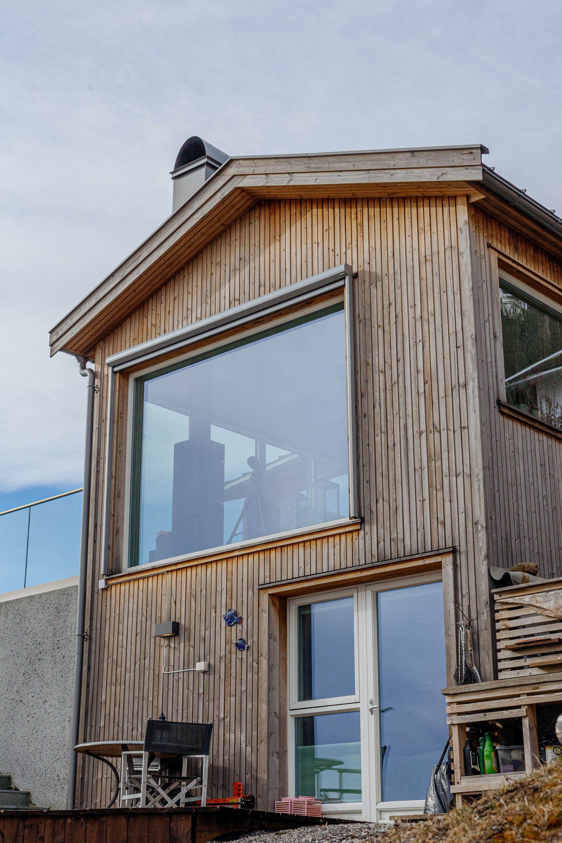 Hytte ved sjøen, store vinduer mot havet.