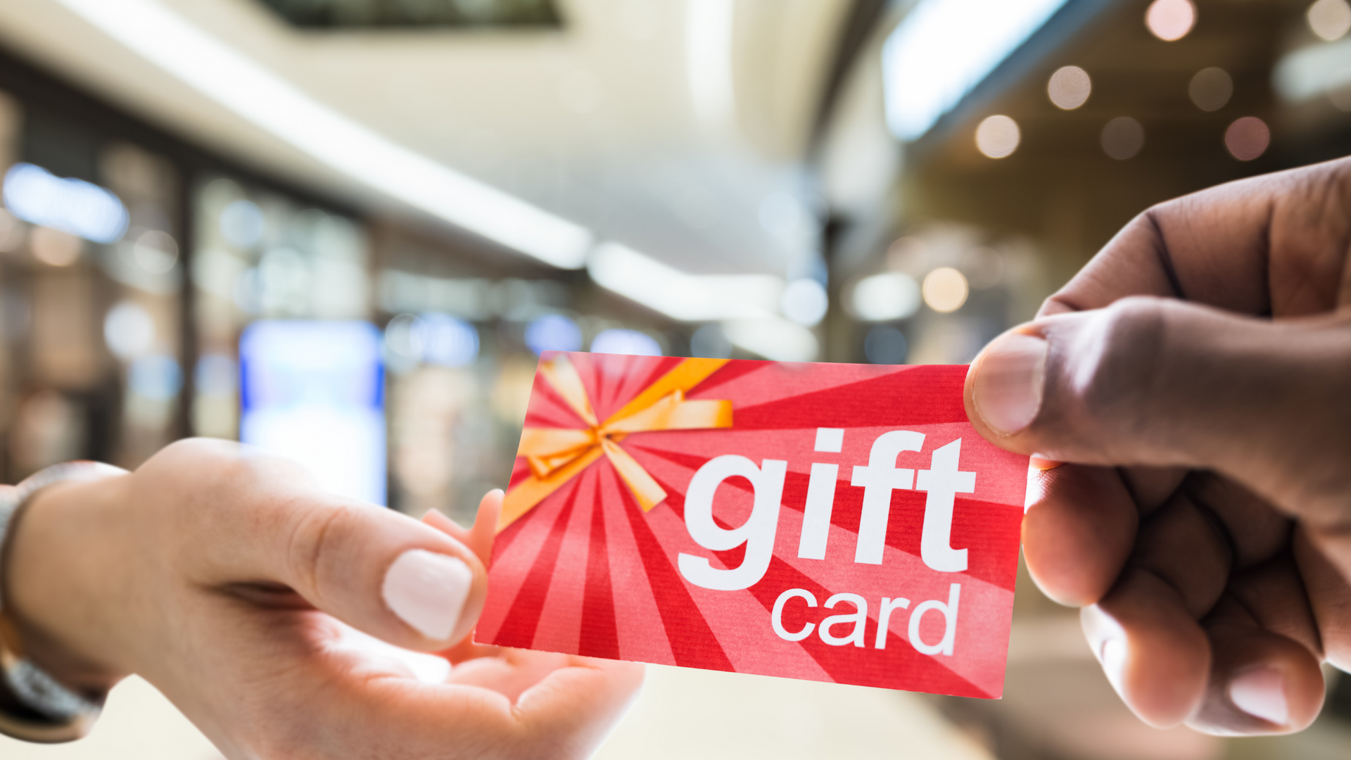 a person is handing a gift card to another person