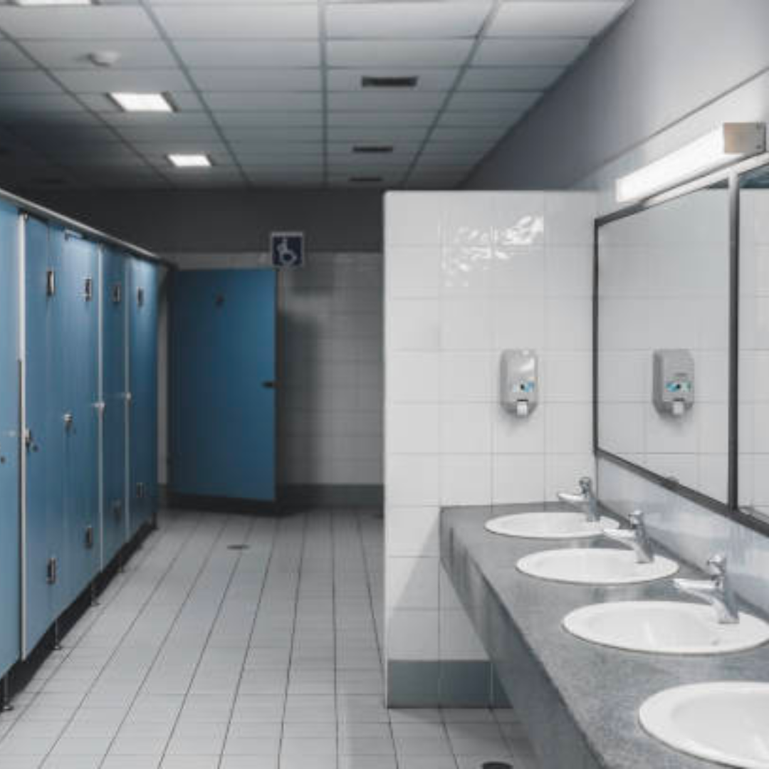 a public restroom with blue lockers and white sinks