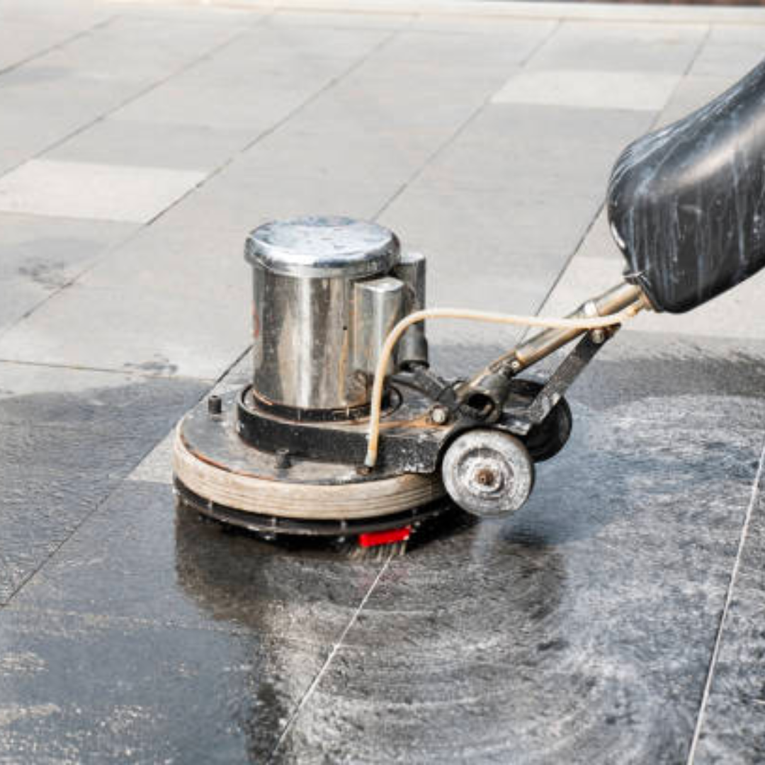 a person is using a machine to clean a tiled floor .