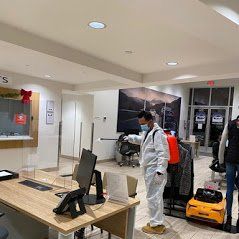 a man in a protective suit is disinfecting a room in an office