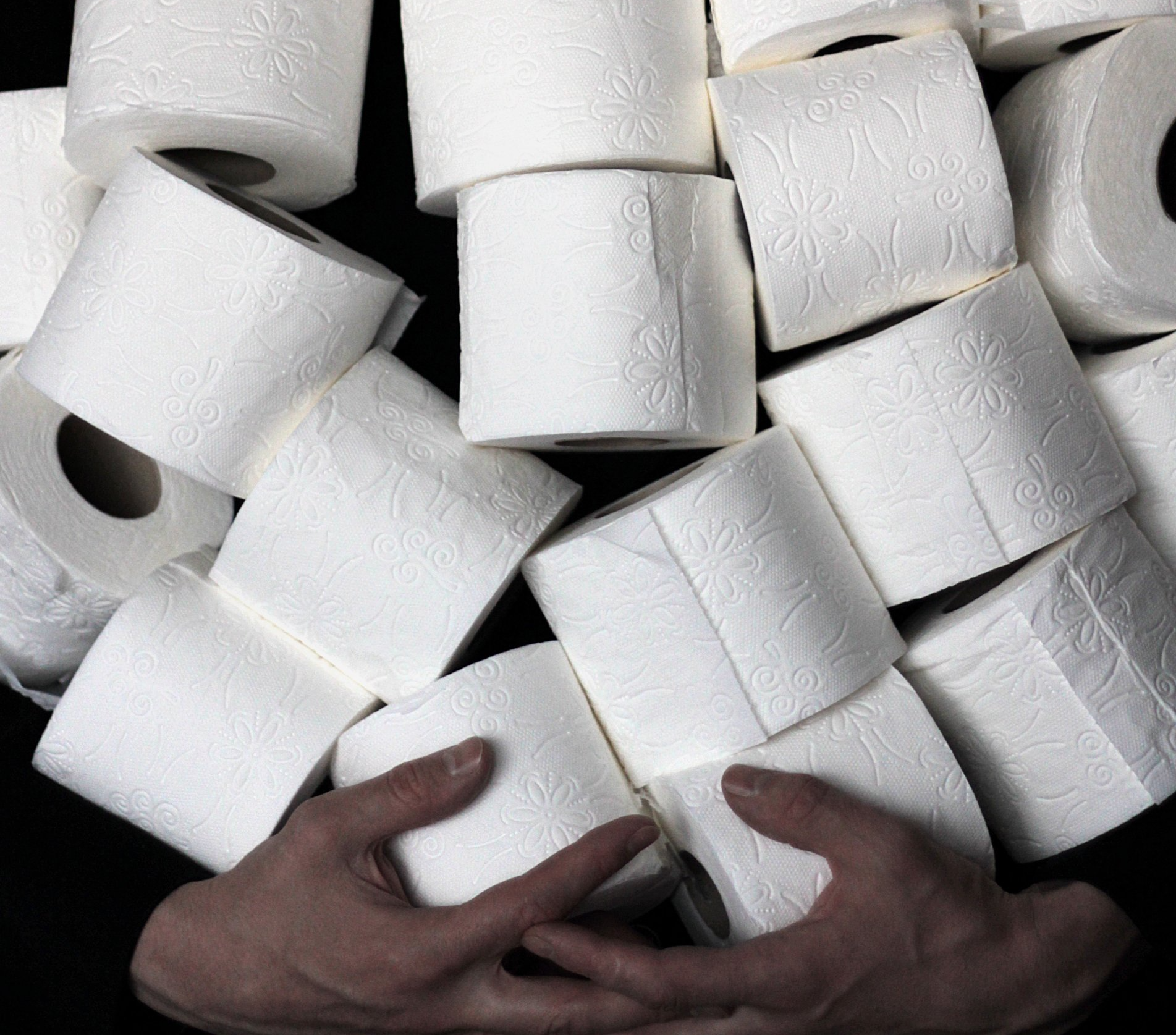 a person is holding a pile of toilet paper in their hands