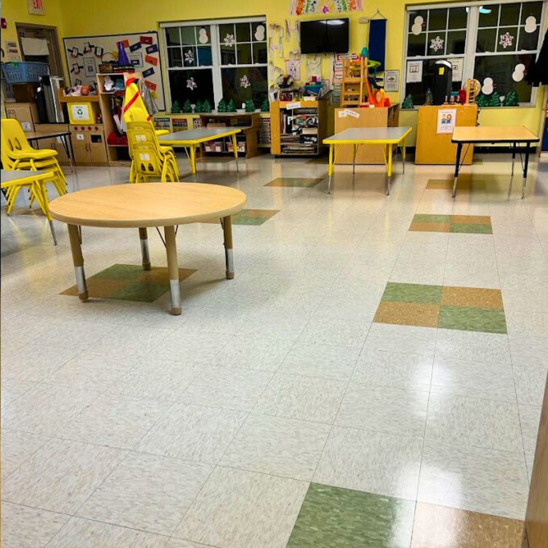 a classroom with tables and chairs and a sign that says play