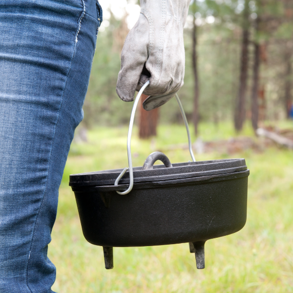 person carrying dutch oven