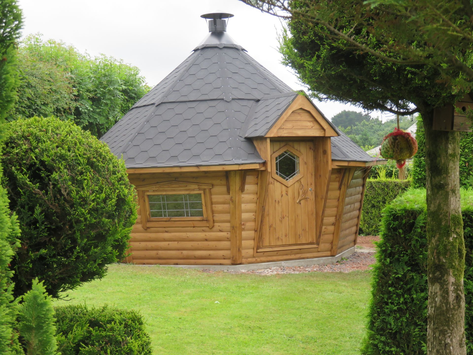 barbecue hut nestled in garden corner