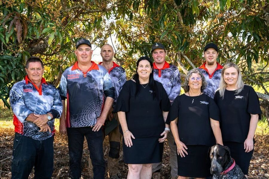 A Group Of People Standing Next To Each Other In Front Of A Tree — Maximum Pest Management In Mareeba, QLD