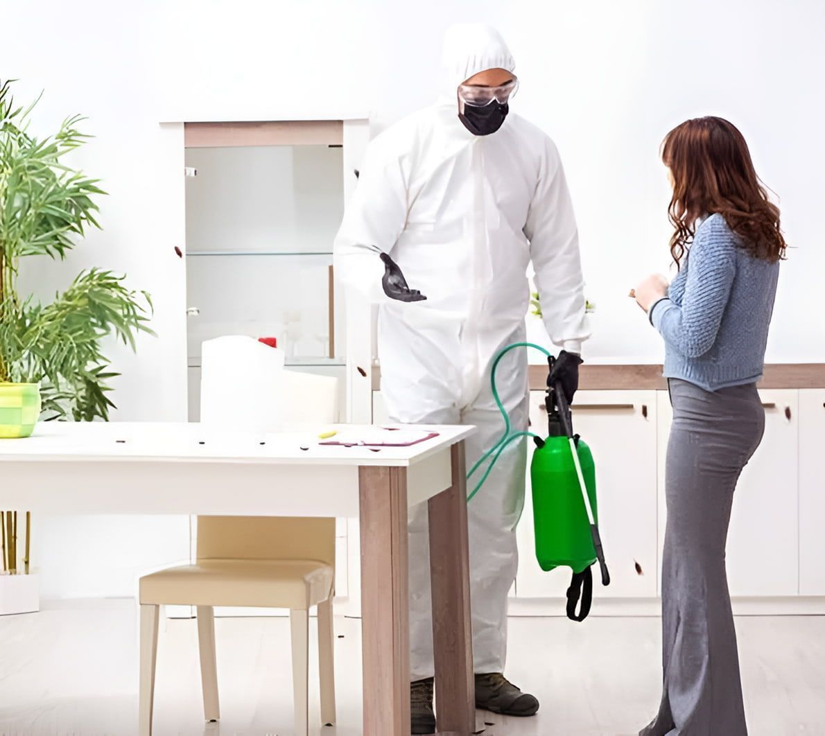 A Man In A Protective Suit Is Spraying A Woman With A Green Spray Bottle — Maximum Pest Management In Mareeba, QLD