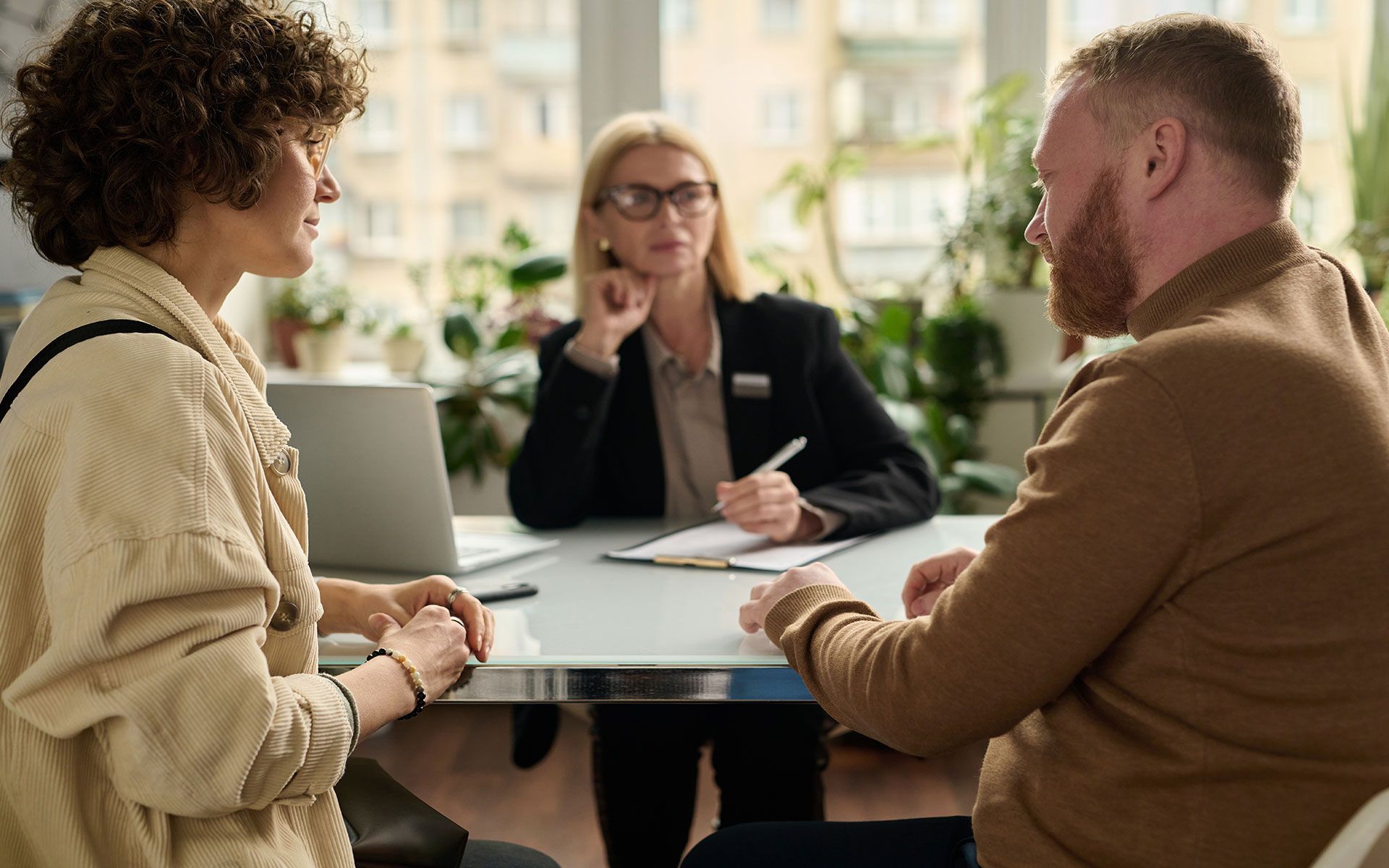 Couple consulting with a professional; indoor office setting.