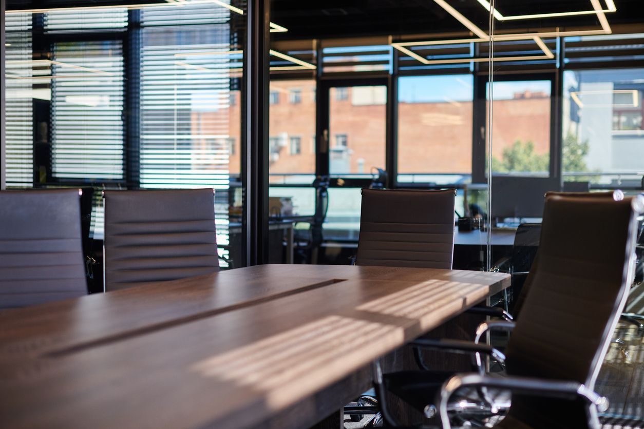 A conference room with a long table and chairs.