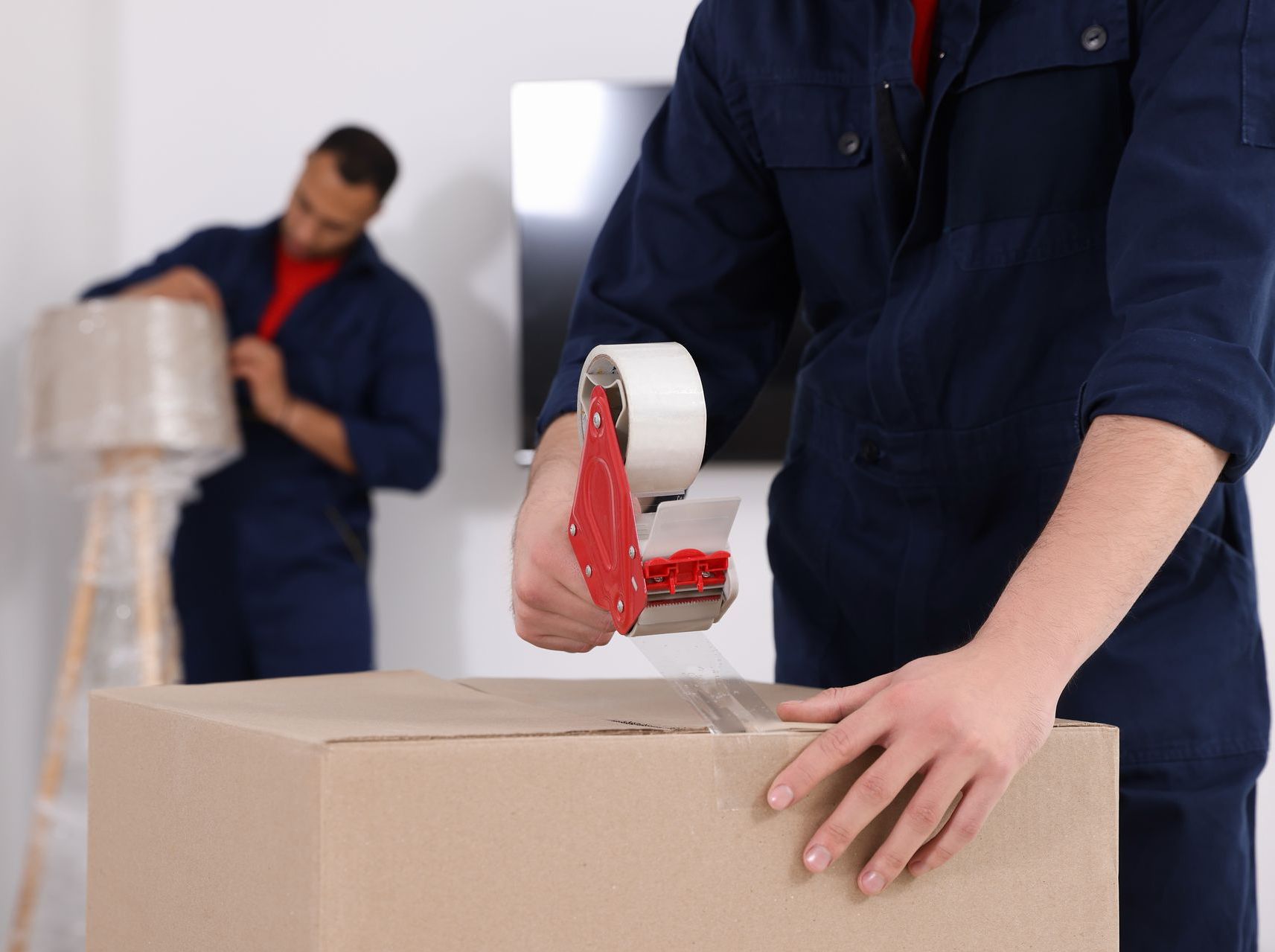 A man is taping a box with tape.