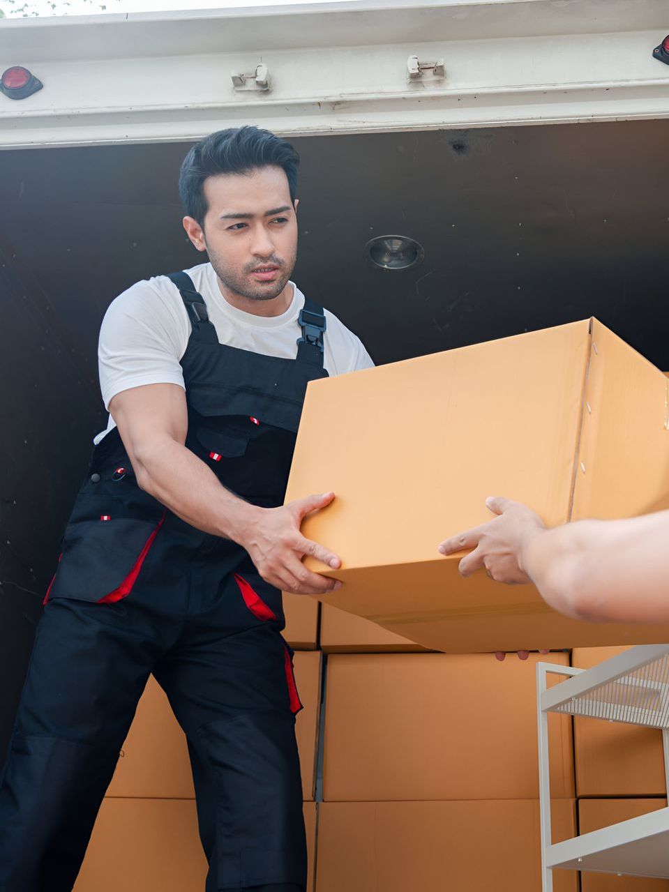 Two men are loading boxes into a moving truck.