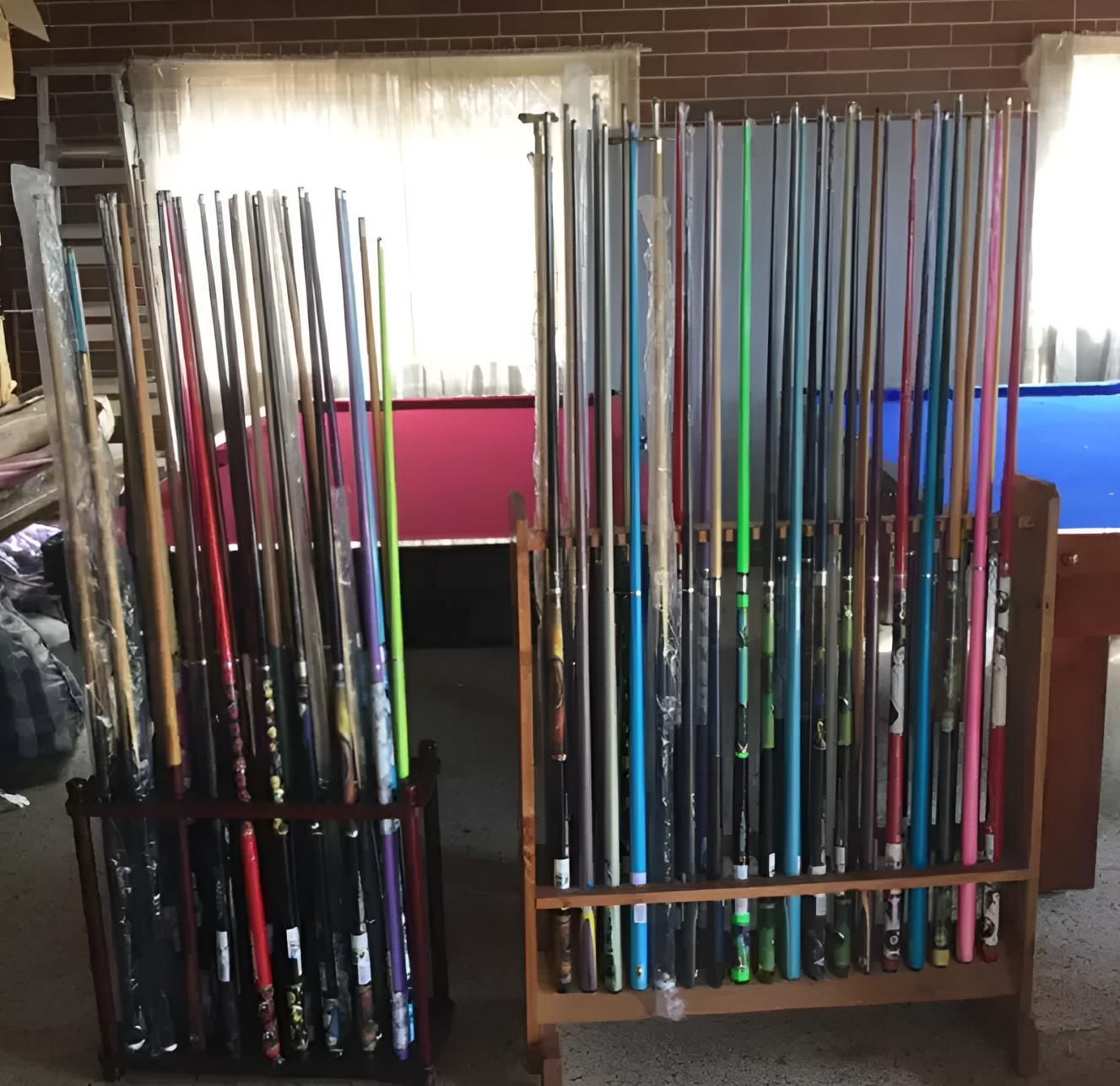 A Rack Full Of Pool Cues With A Pool Table In The Background — Eight Ball Services In Taranganba, QLD