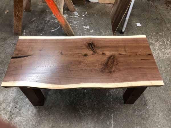 A wooden table is sitting on top of a concrete floor.