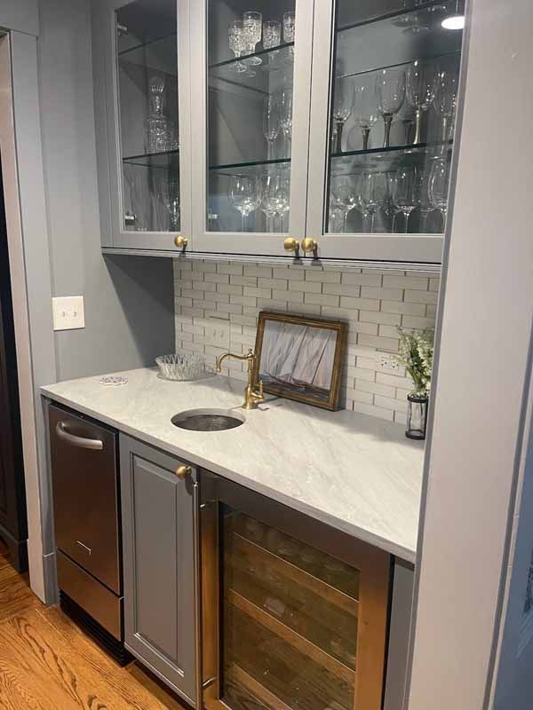 A kitchen with stainless steel appliances , a sink , and a wine cooler.