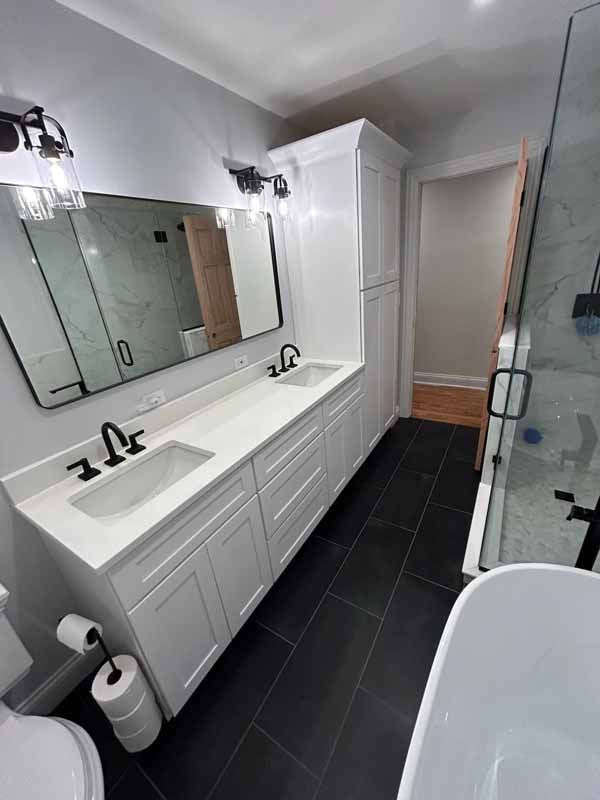 A bathroom with two sinks , a toilet , and a bathtub.