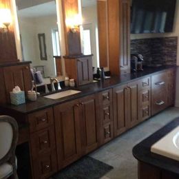 A bathroom with wooden cabinets a sink and two mirrors