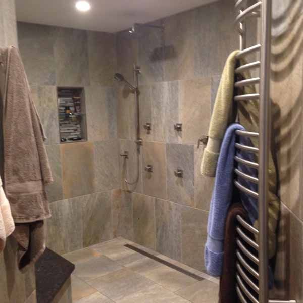A bathroom with a walk in shower and a towel rack