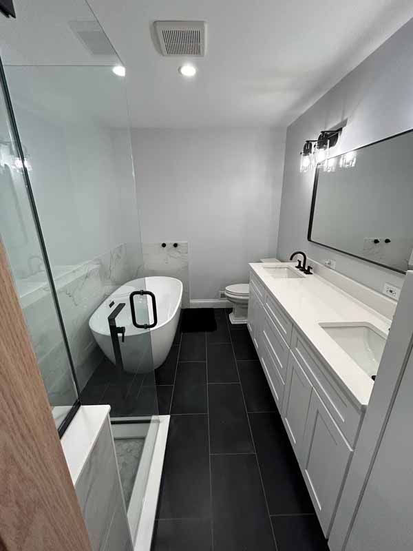 A bathroom with a tub , sink , toilet and shower.