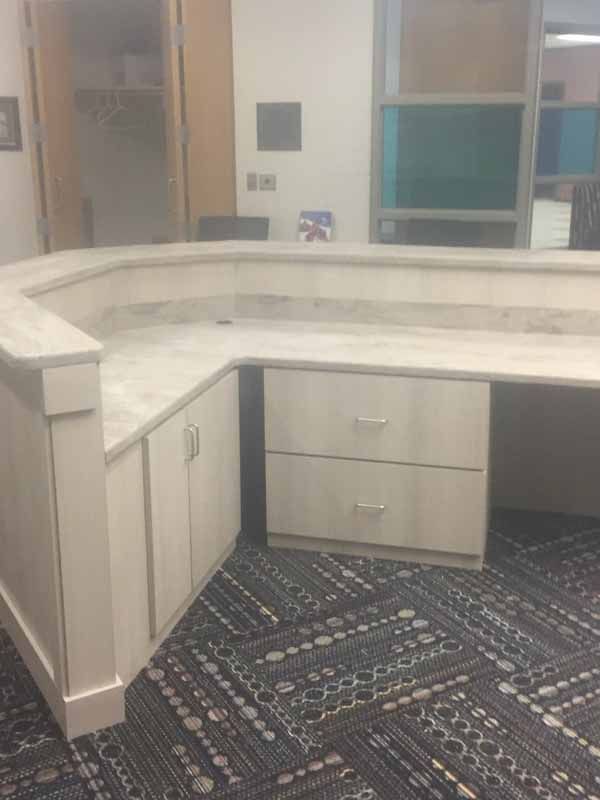 A reception desk with drawers and cabinets in a room.