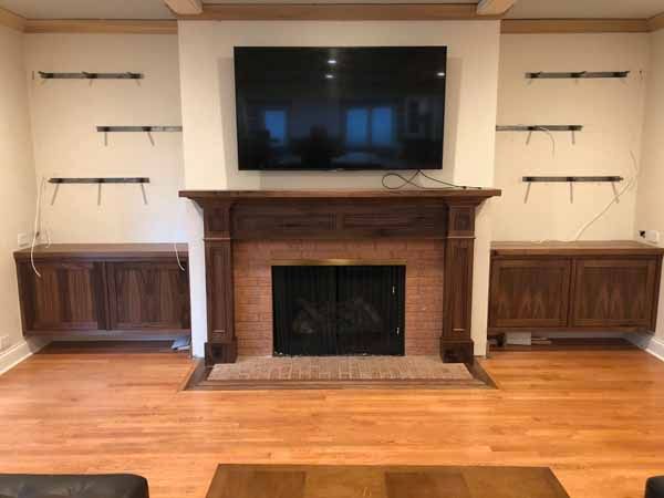 A living room with a fireplace and a flat screen tv on the wall.