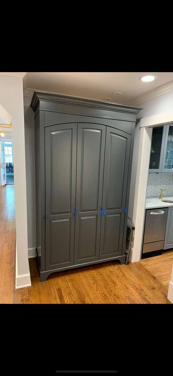A large gray cabinet is sitting in a kitchen next to a sink.