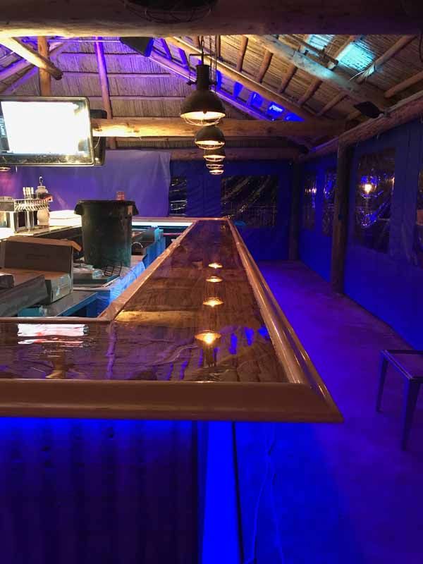 A long bar in a dark room with blue lights.