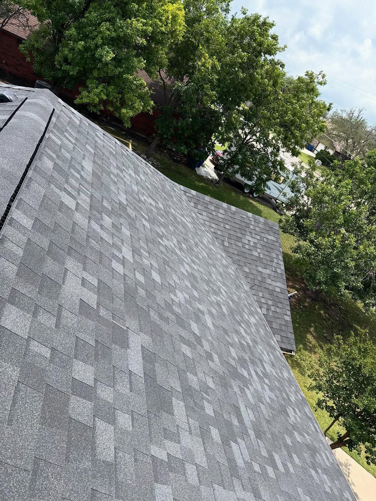 A close up of a roof with trees in the background.