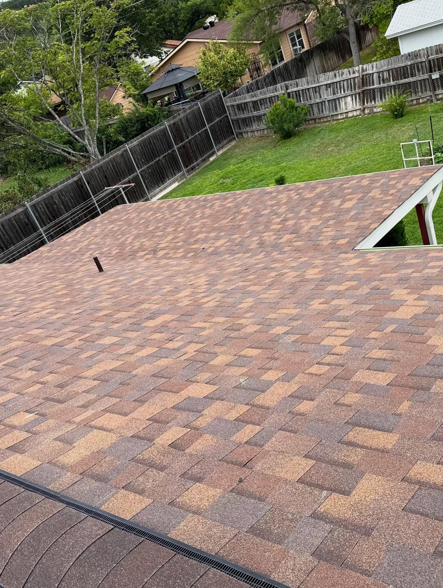 A close up of a roof with a fence in the background.