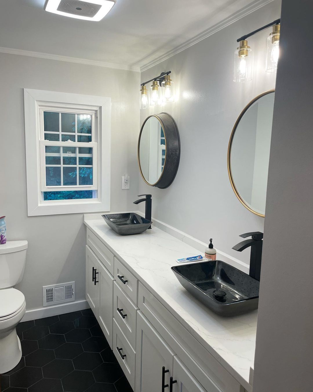 A bathroom with two sinks and two mirrors