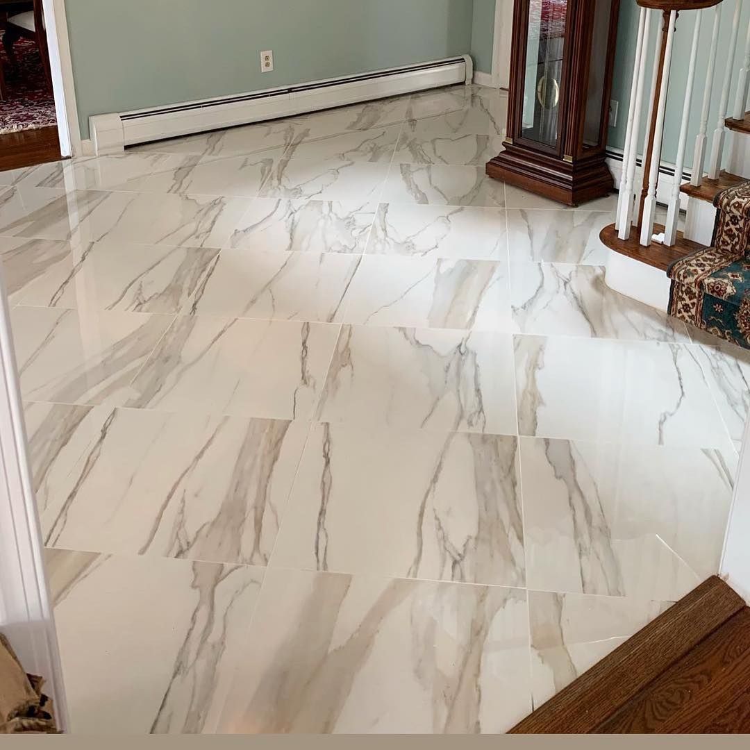 A marble floor in a room with stairs and a clock