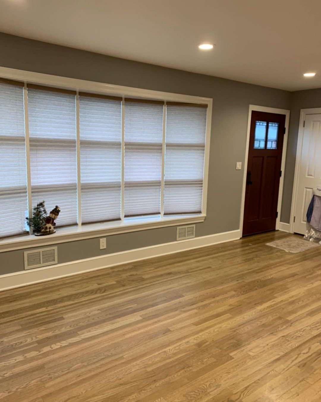 A living room with hardwood floors , a window , and a door.