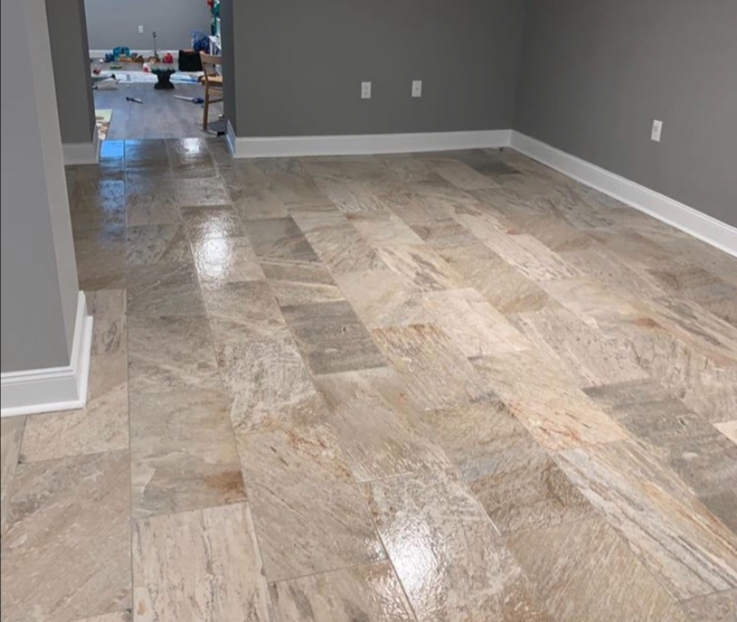 A room with a tiled floor and a gray wall.