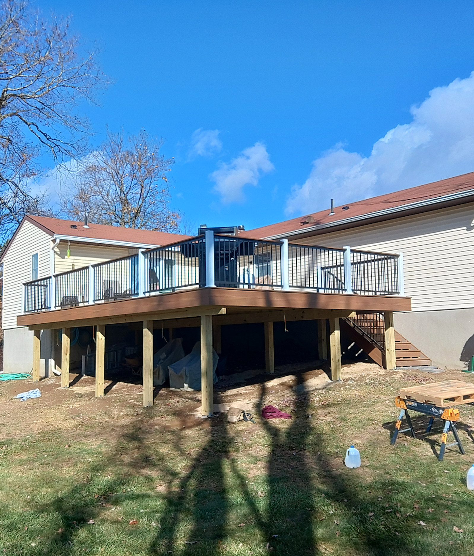 A large wooden deck is being built in front of a house.
