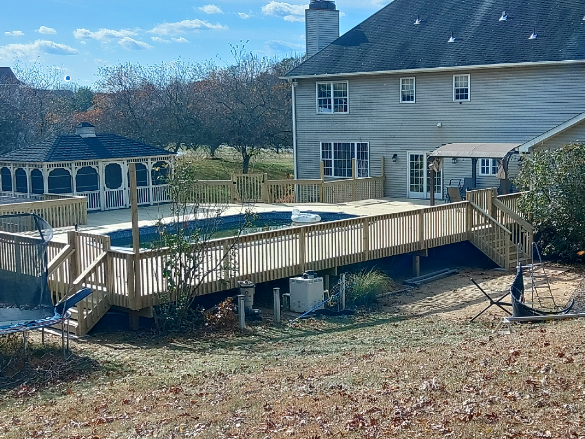 A large house with a swimming pool and a wooden deck.