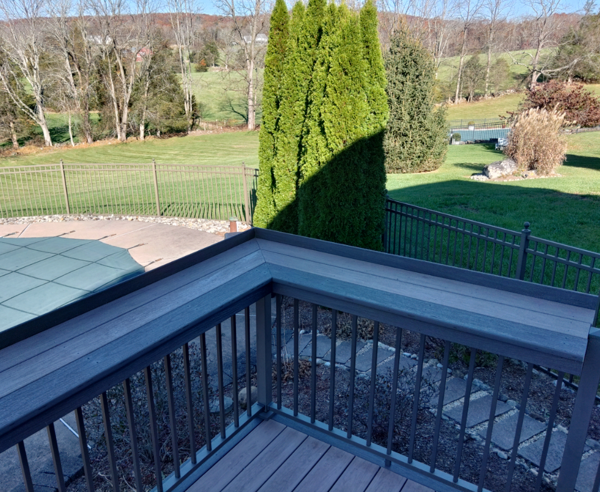 A balcony with a view of a field and trees.