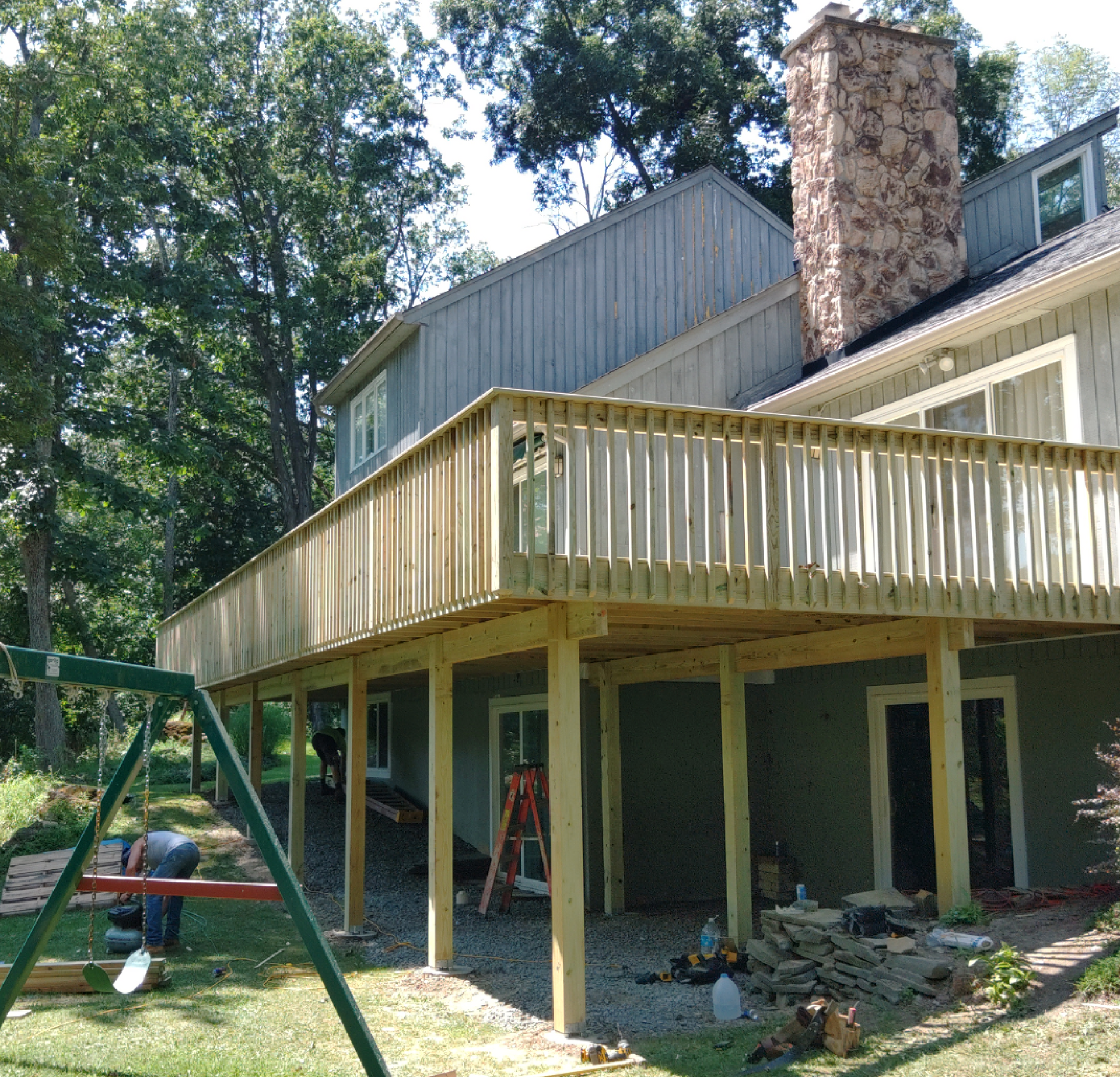 A wooden deck is being built in front of a house