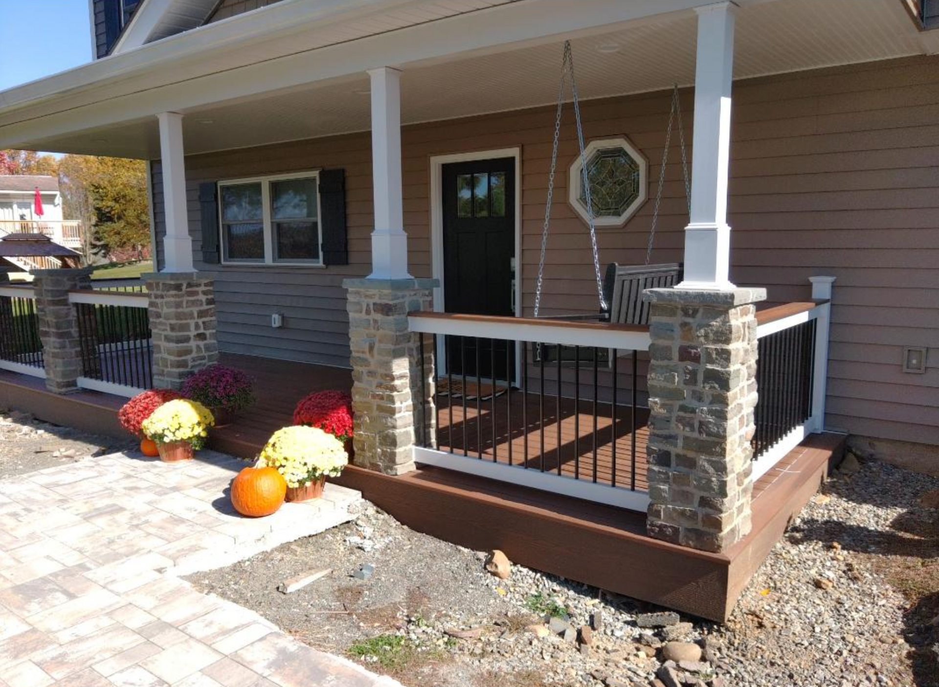 A porch with flowers and pumpkins on it